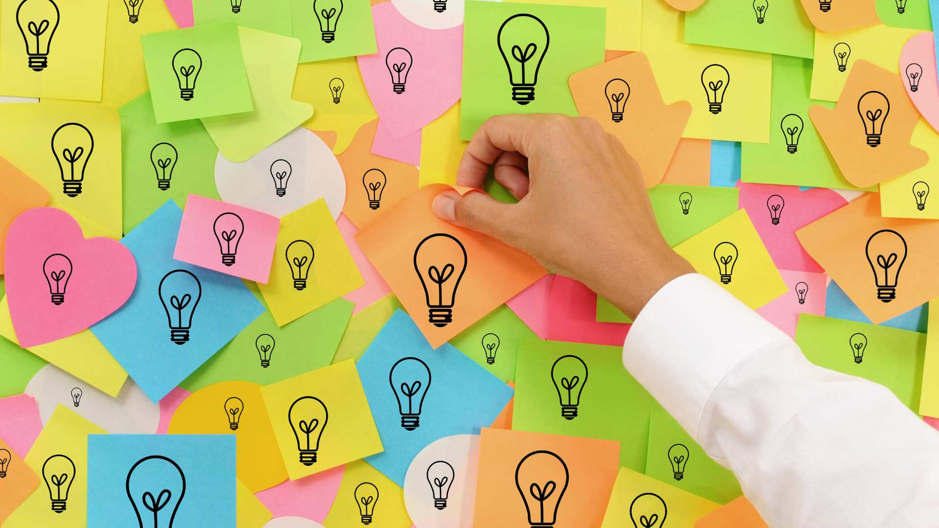 Dizaines de post-it accroché sur un mur avec des ampoules dessiné dessus