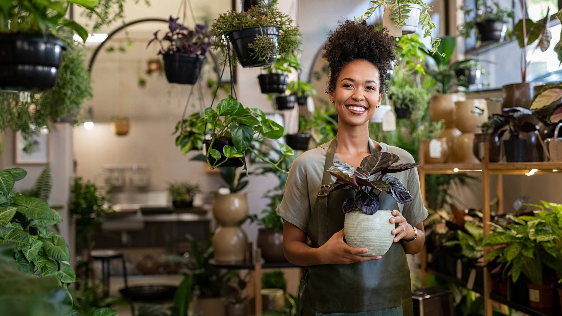 Femme dans sa boutique de fleurs et de plantes